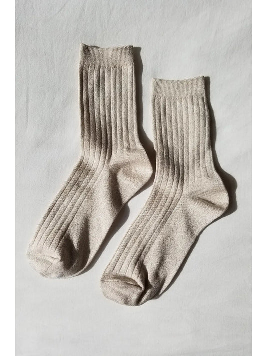 Pair of beige socks on a light gray background