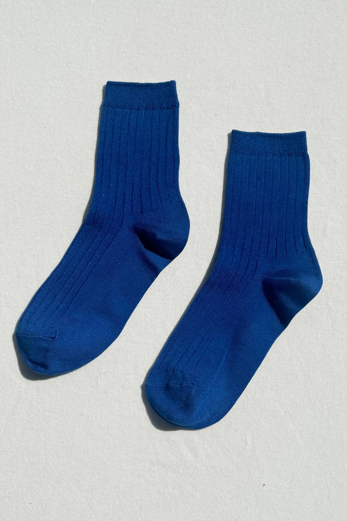 Pair of blue socks on a light gray background
