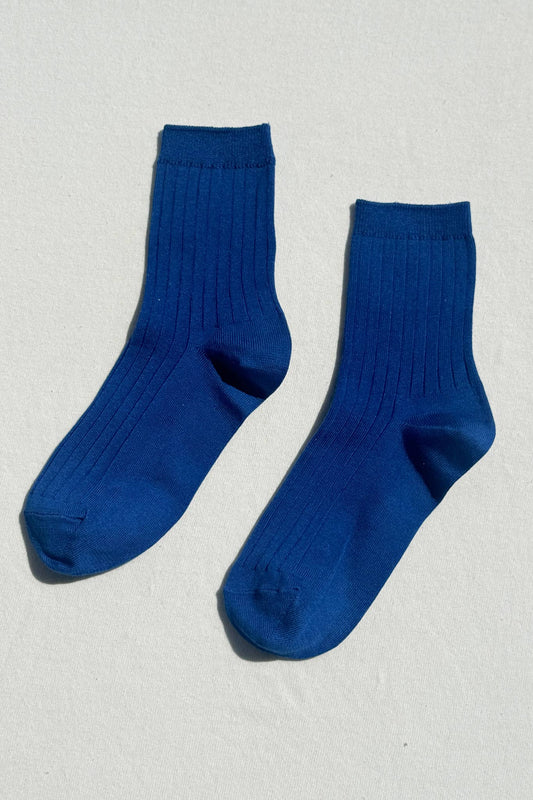 Pair of blue socks on a light gray background
